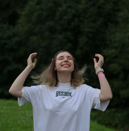 Mujer joven con los ojos cerrados y expresión de calma al aire libre, representando libertad e independencia personal