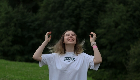 Independizarse. Mujer joven con los ojos cerrados y expresión de calma al aire libre, representando libertad e independencia personal