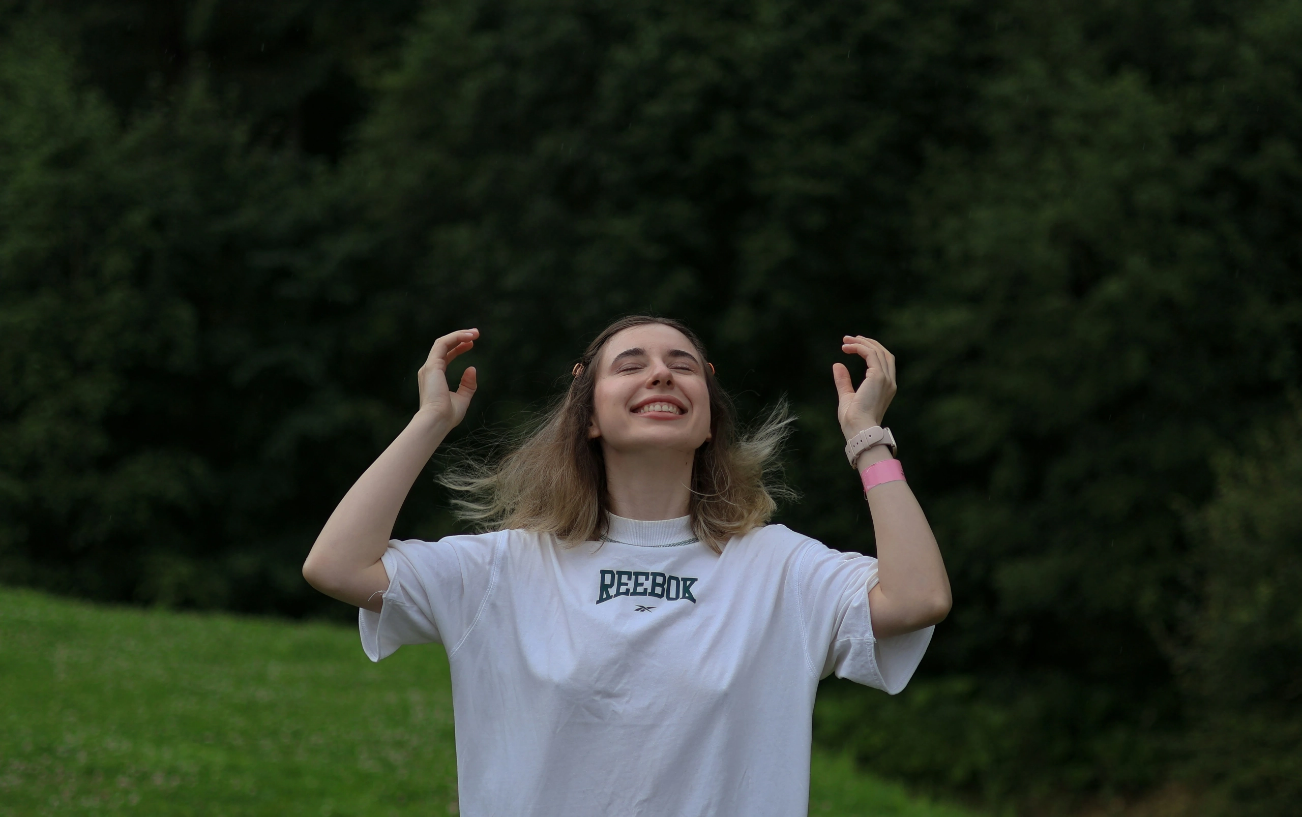 Mujer joven con los ojos cerrados y expresión de calma al aire libre, representando libertad e independencia personal