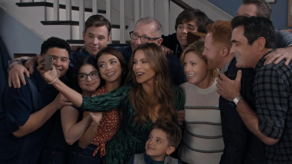 Familia de Modern Family reunida en una sala, serie de comedia sobre dinámicas familiares y vida cotidiana